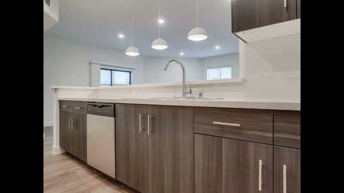 Modern kitchen with stainless steel appliances, granite countertops, and pendant lighting.