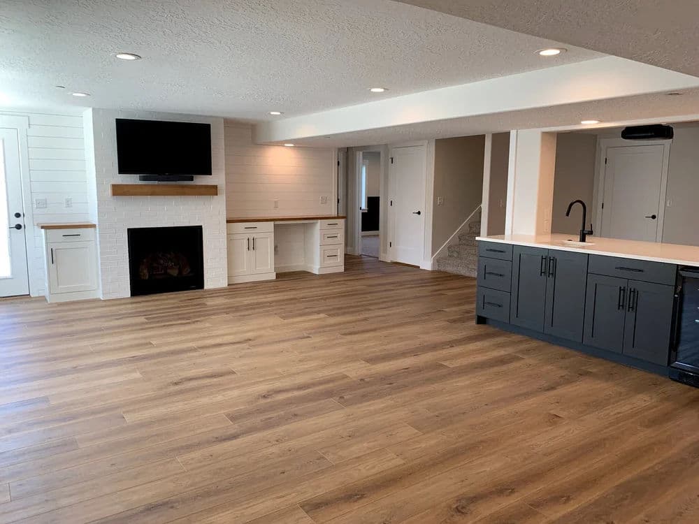 Modern open-concept living area with hardwood flooring, fireplace, and kitchen island.