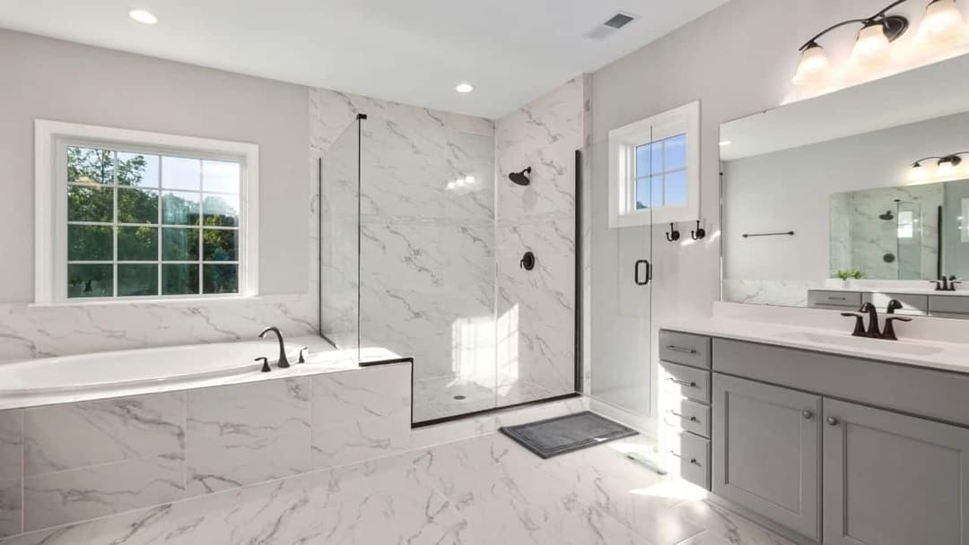 Modern bathroom featuring a walk-in shower, freestanding tub, and elegant marble tiles.
