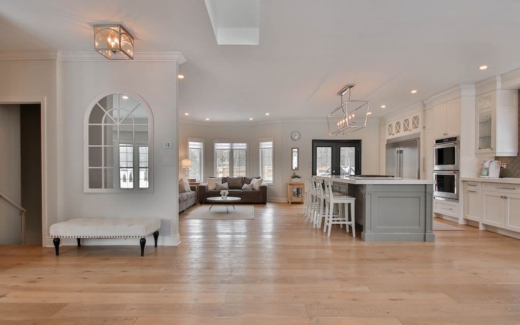 Spacious modern kitchen and living room with natural light and elegant decor.