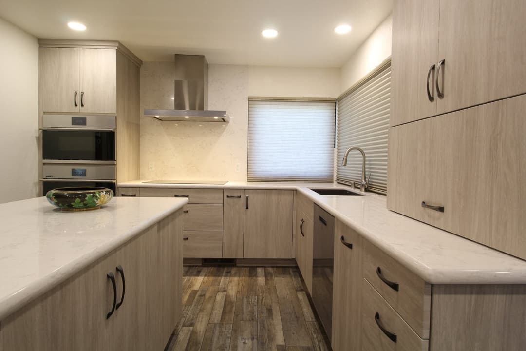 Modern kitchen design with wood cabinetry, quartz countertops, and stainless steel appliances.